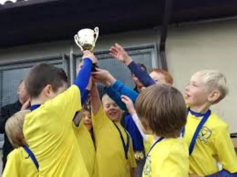 Players lifting a trophy in their yellow kit
